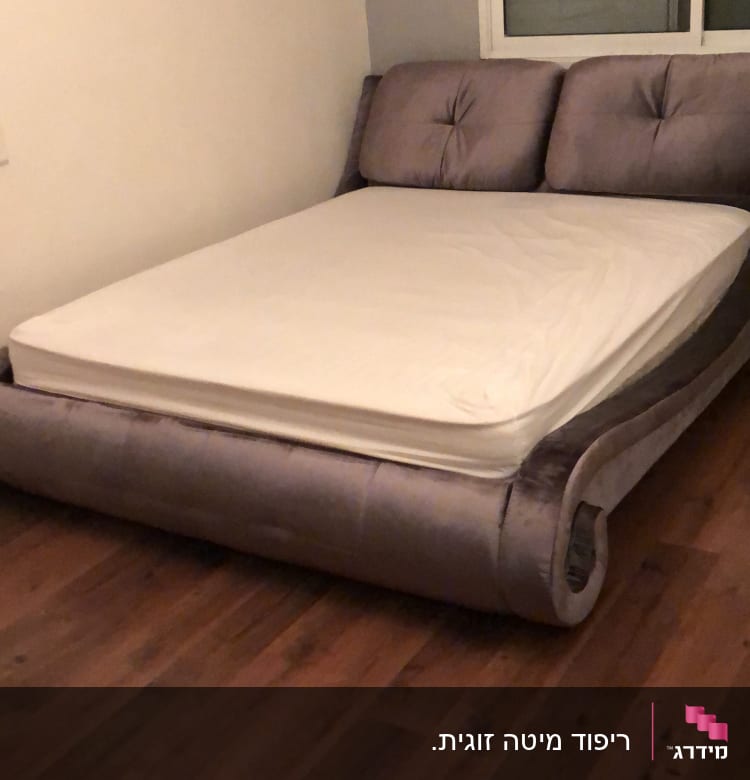 מיטה מרופדת עם מזרן לבן בחדר שינה